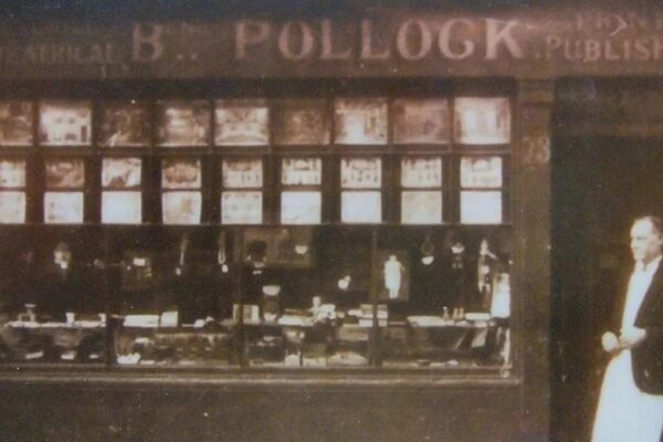 A black and white photo of Benjamin Pollock standing outside his shop in Hoxton Street