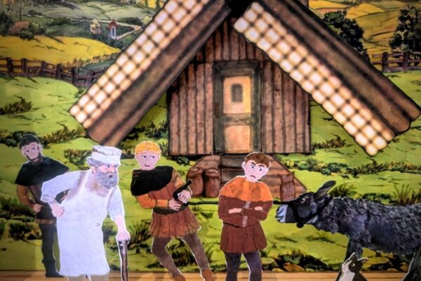 Photo of toy theatre performance of Puss in Boots, featuring a scene with four men, a cat and a donkey.